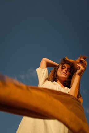 a woman in a white dress is holding a cat