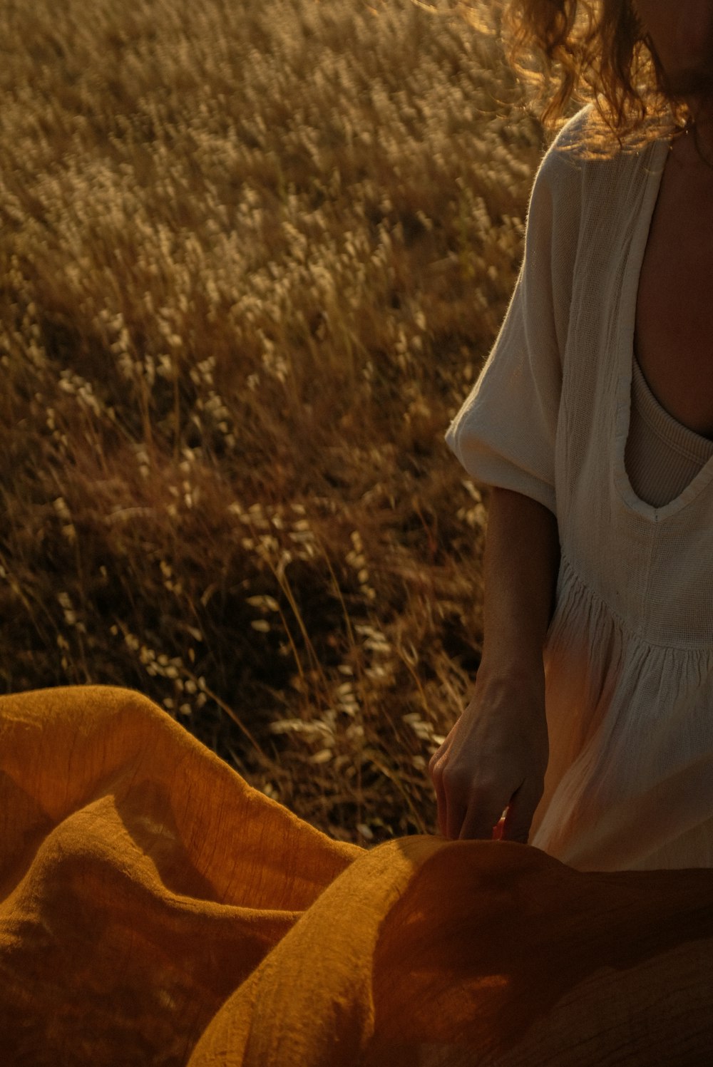 uma mulher em um vestido branco sentado em um campo