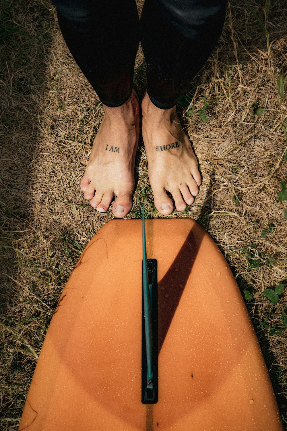 a person standing on top of a surfboard in the grass