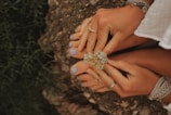 a woman holding a ring on top of a rock
