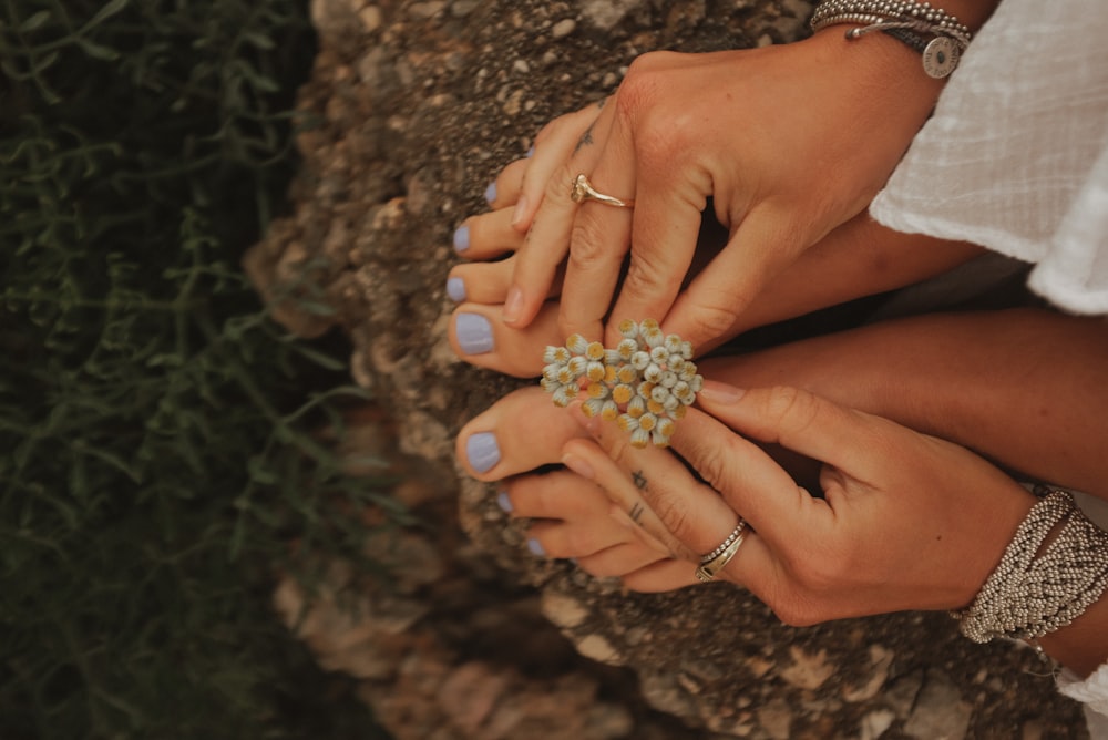 a woman holding a ring on top of a rock