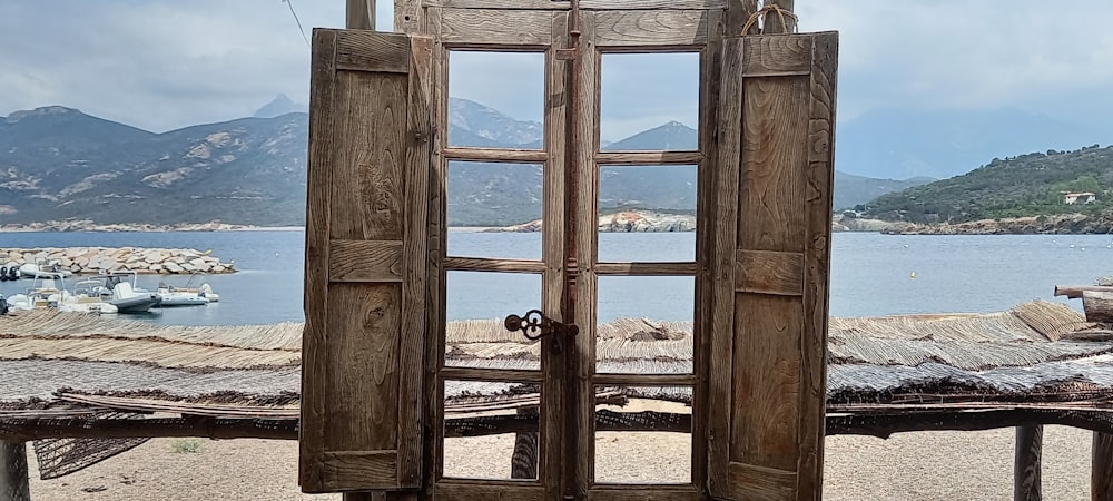 an open wooden door with a view of a body of water