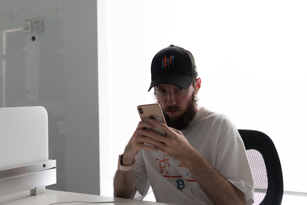 a man sitting at a desk using a cell phone