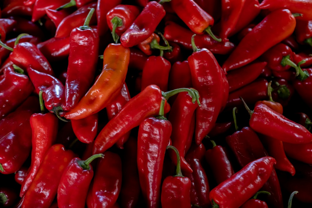 a pile of red hot peppers sitting on top of each other
