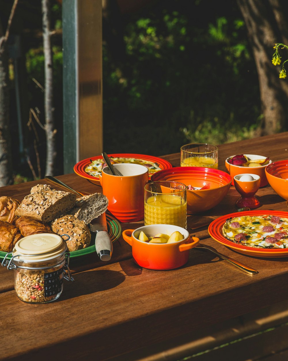 una mesa de madera cubierta con platos y cuencos de comida