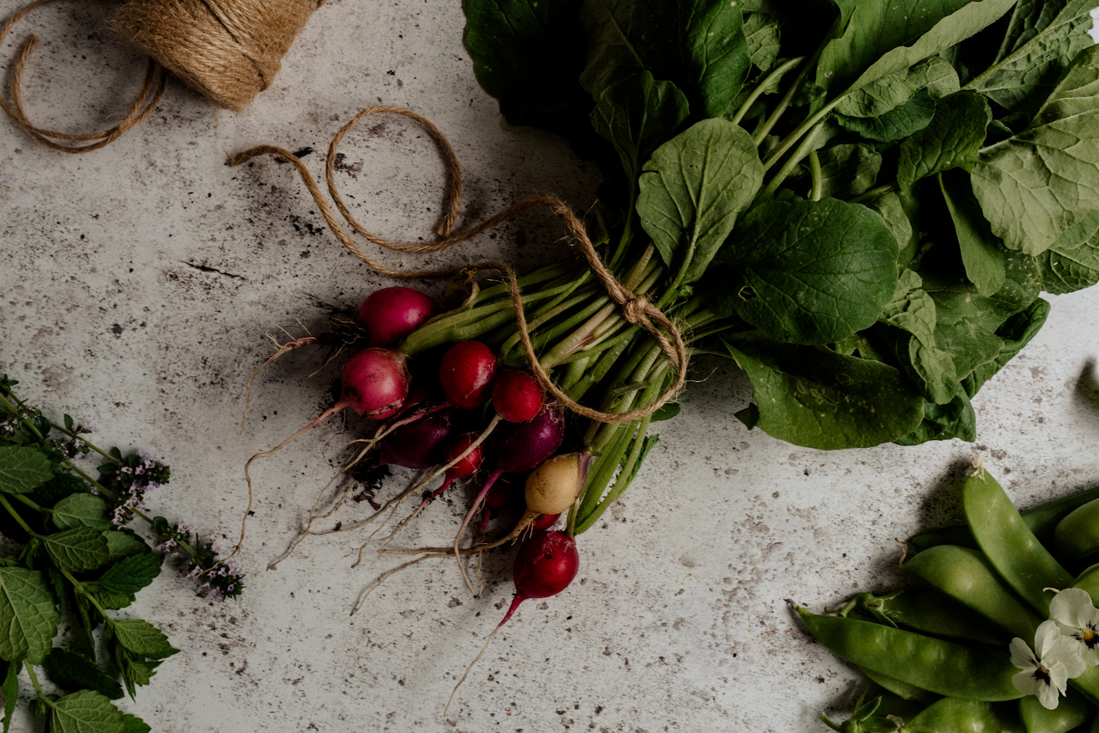 Fresh food Flagstaff, a bunch of radishes and kitchen garden herbs on a wooden table
