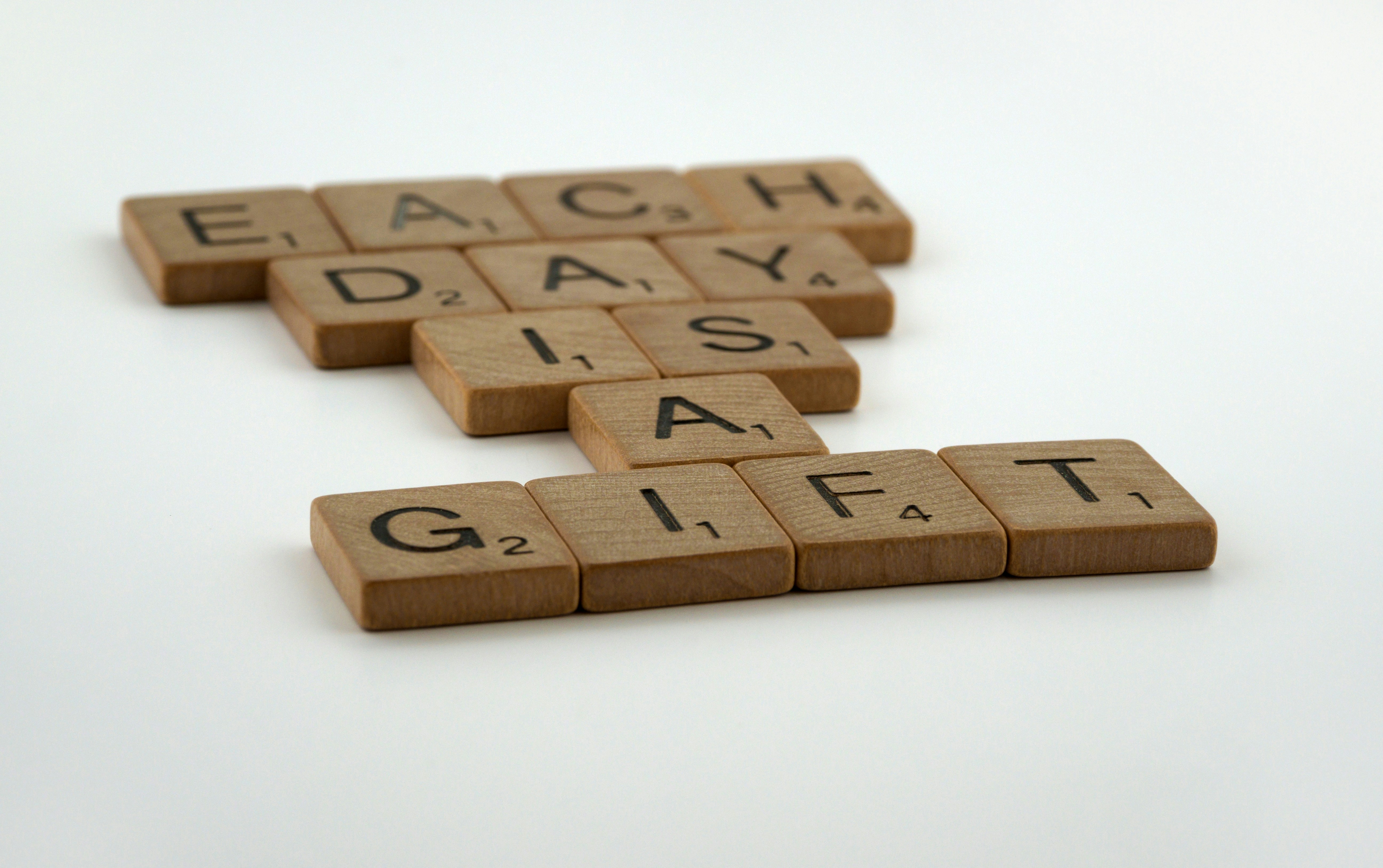 scrabble tiles, tiles, scrabble, white background, letters, lettering, typography, wood tiles, wooden tiles, words, phrases, each day is a gift, seize the day, seize the moment, you said tomorrow yesterday, just do it, carpe diem, yolo, procrastination, live life, discipline, exercise, don't put it off, inertia, if not now when, don't delay, work hard, stop putting things off, enjoy life, carpe momentum,