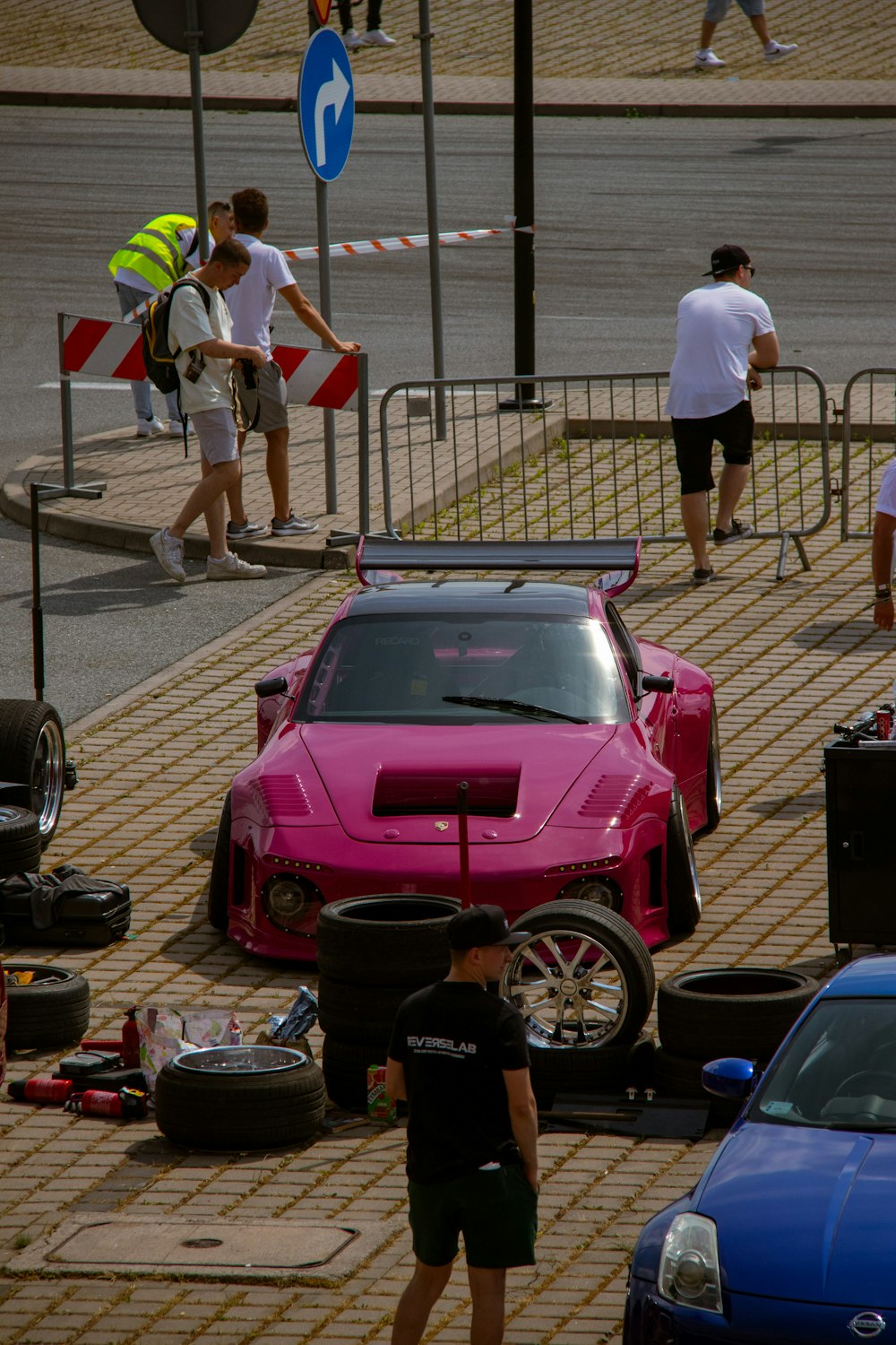 a pink car is parked on the side of the road