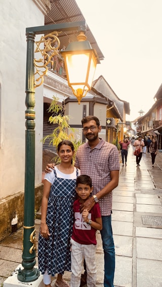 A family excitedly examining a treasure map on a sunny city street, surrounded by charming old buildings.