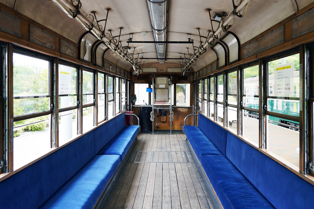 a long blue bench sitting inside of a train