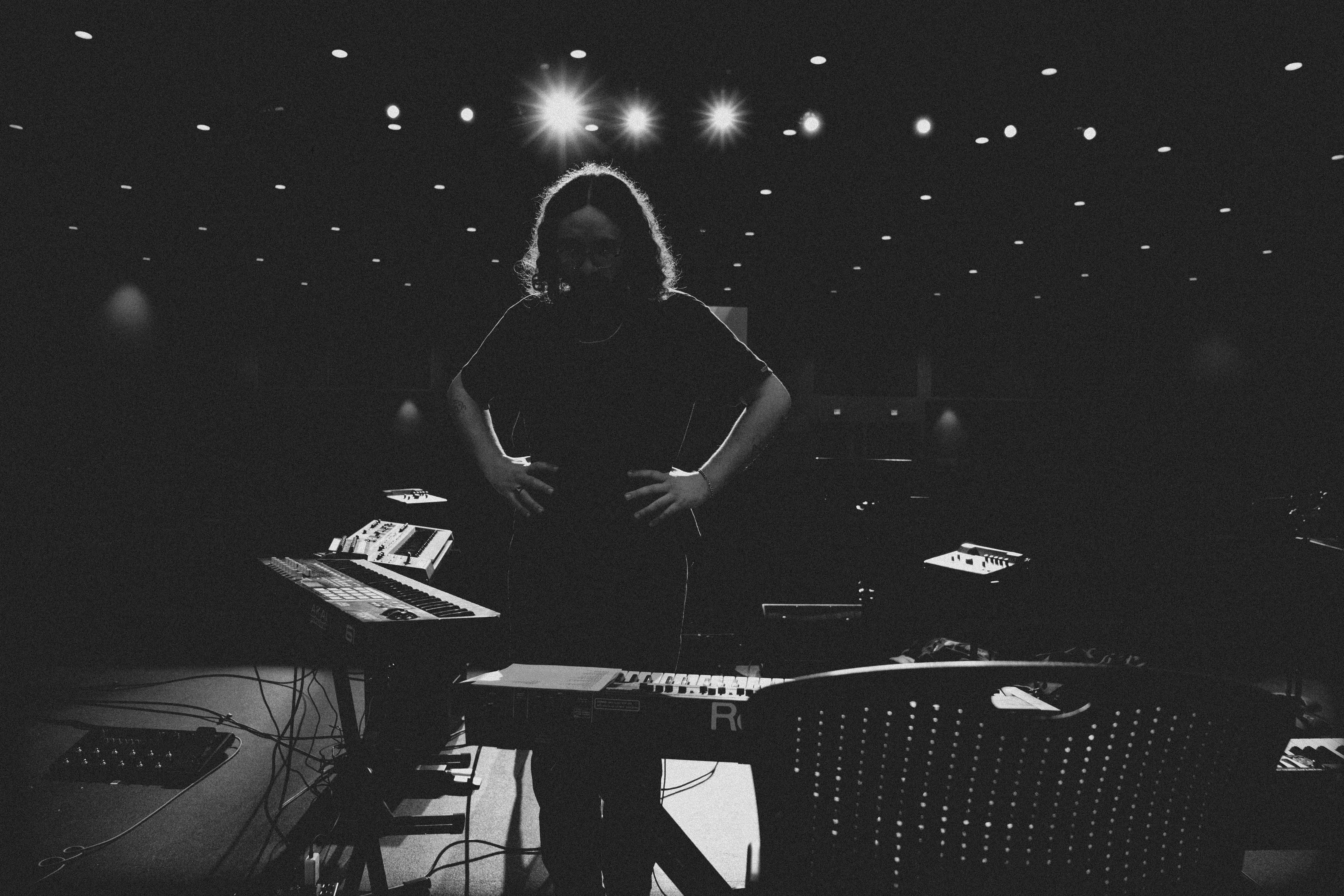 a woman standing in front of a keyboard in a dark room