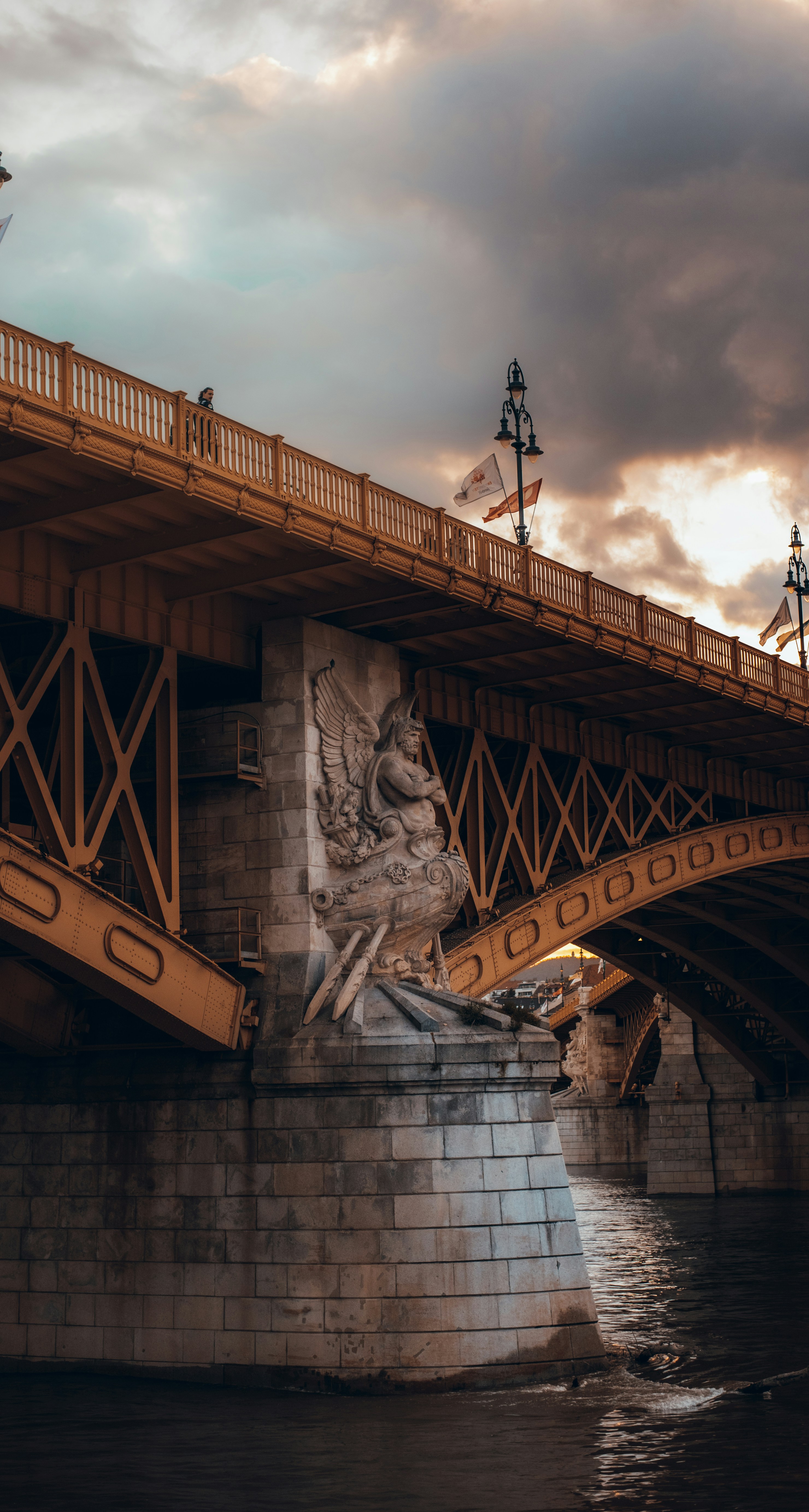a bridge over a body of water under a cloudy sky
