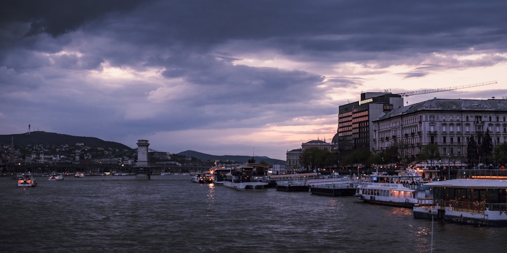 a river filled with lots of boats under a cloudy sky