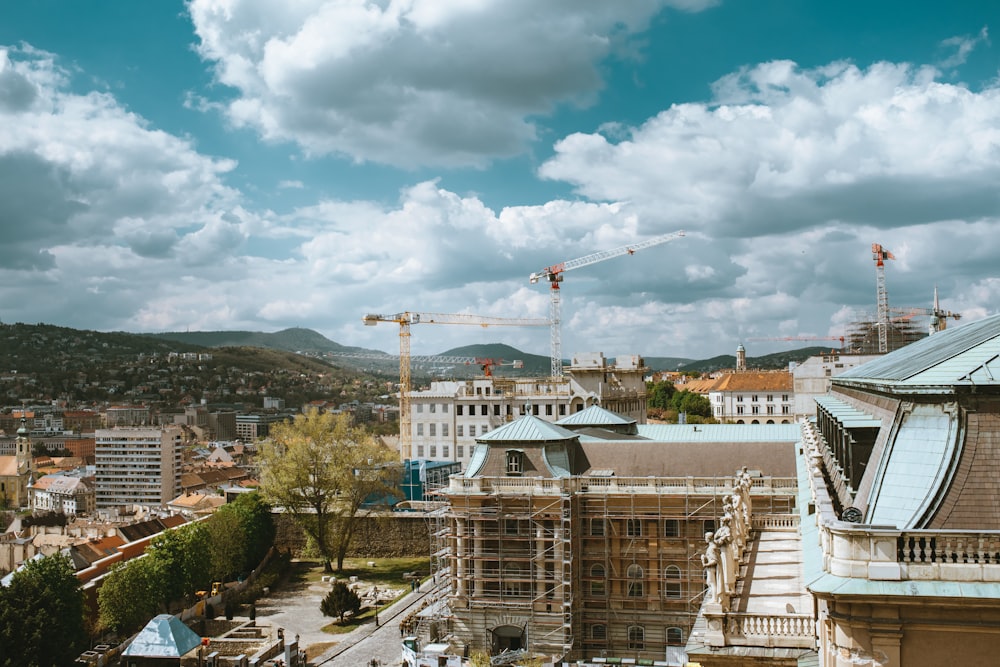 a view of a city with cranes in the background