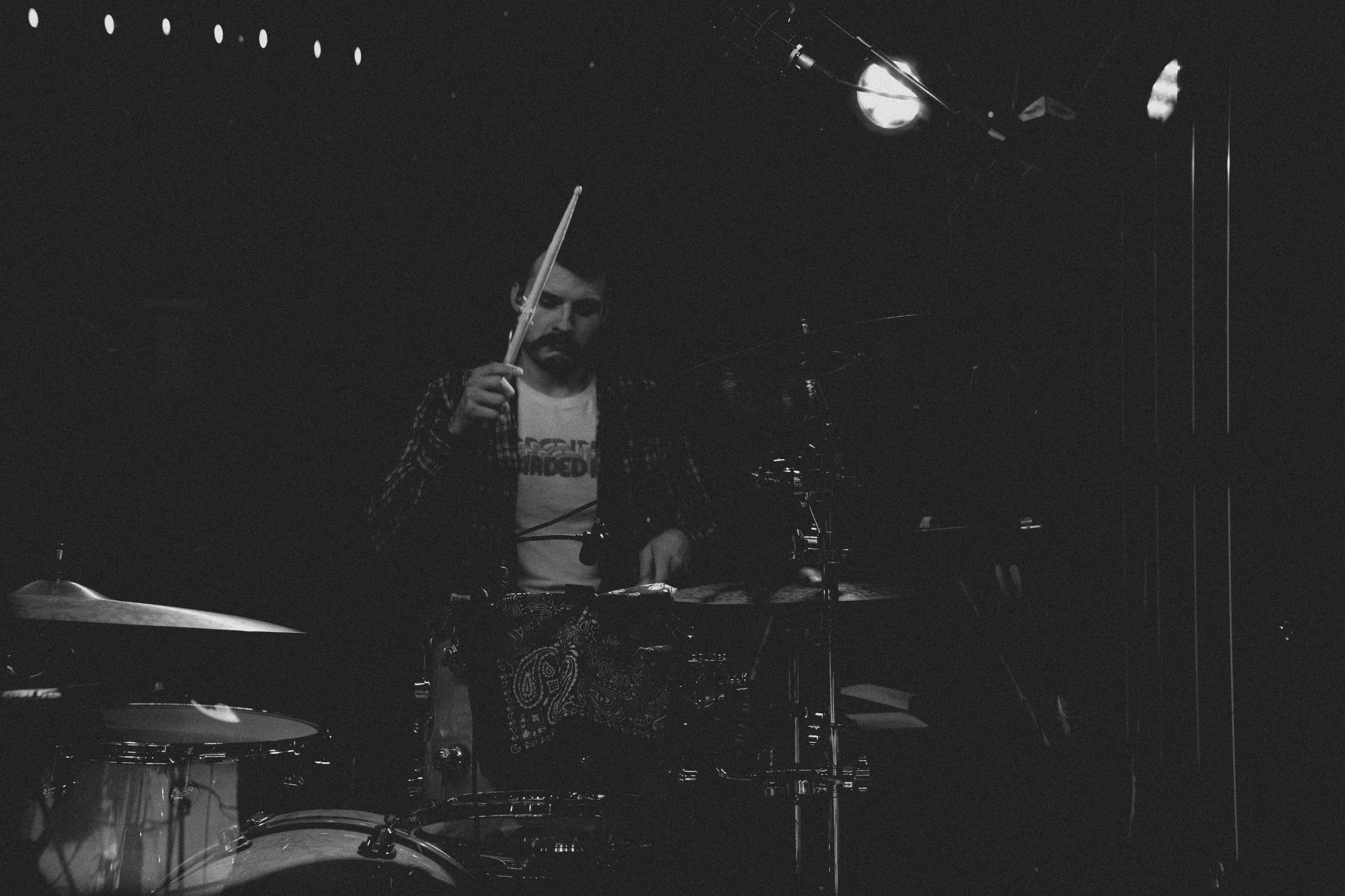 a man sitting in front of a drum set