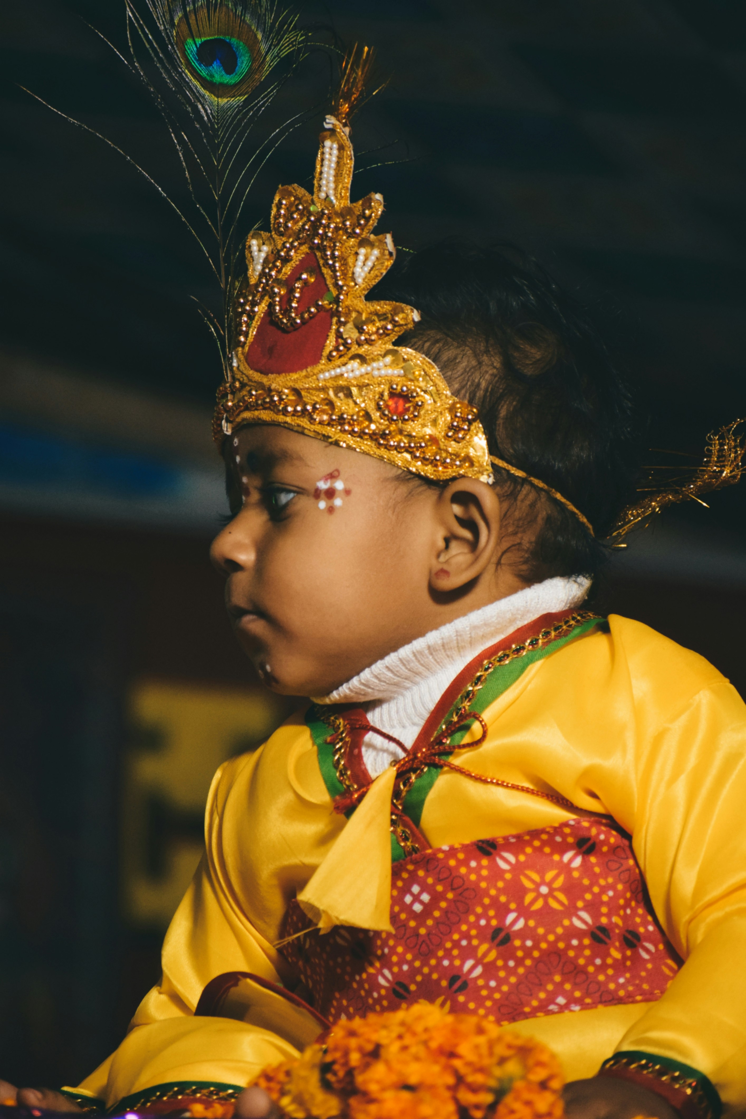 A little girl wearing a costume and a peacock feather photo Free Lord