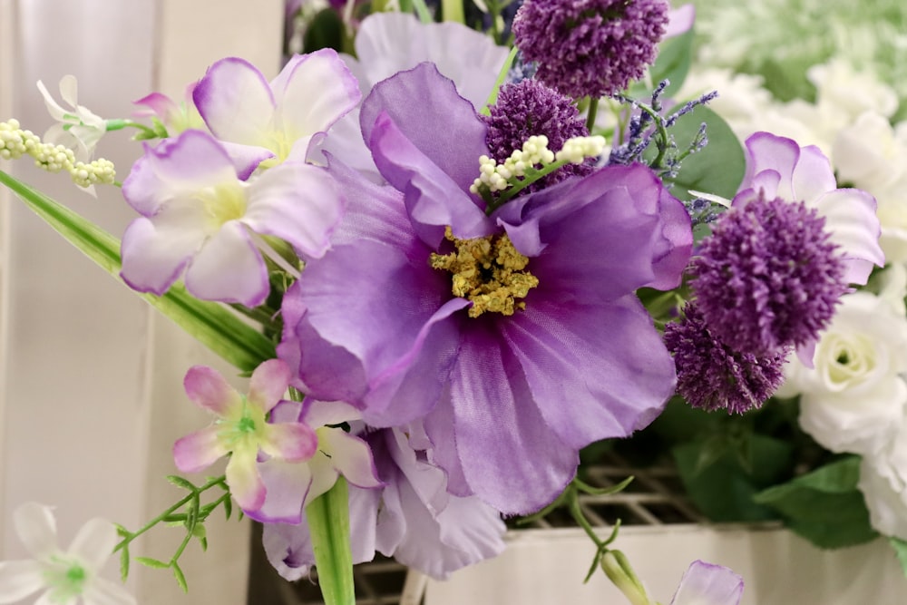 a vase filled with purple and white flowers