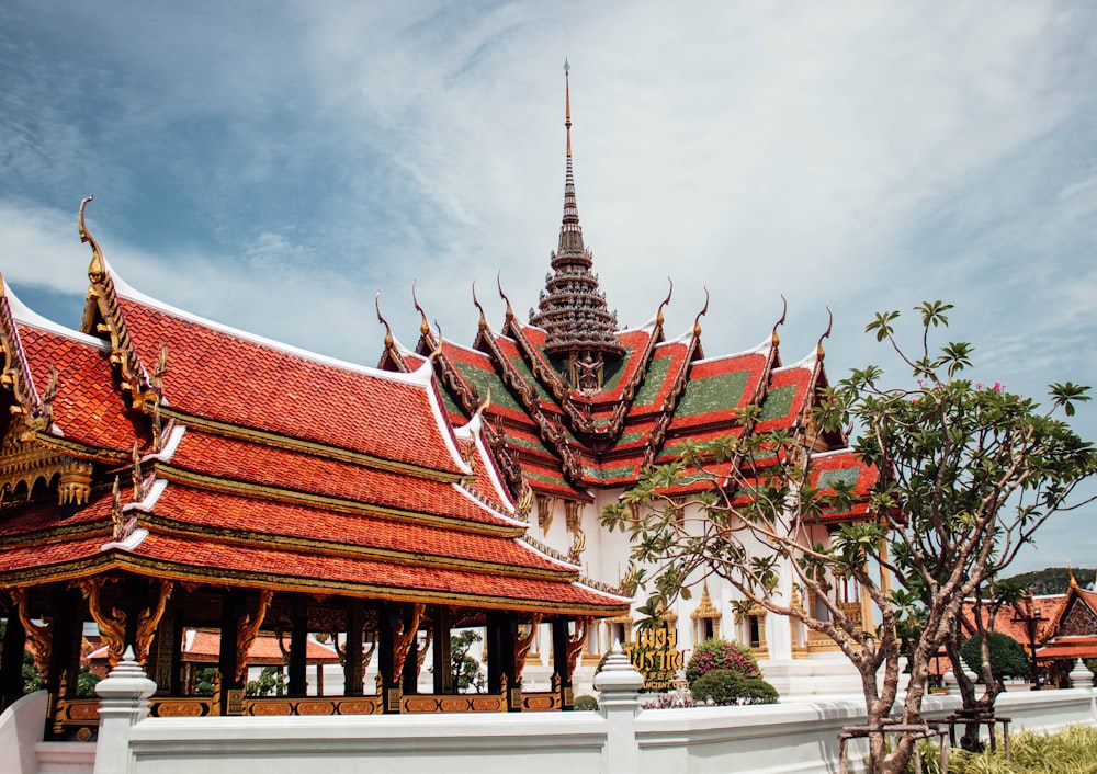 a building with a red roof and a white fence