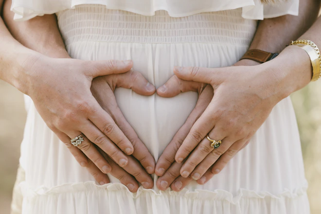 a woman holding her hands in the shape of a heart