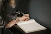 Elegant woman journaling in soft natural light, symbolizing introspection and growth.