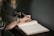 Close-up of a thoughtful woman writing notes in a journal.