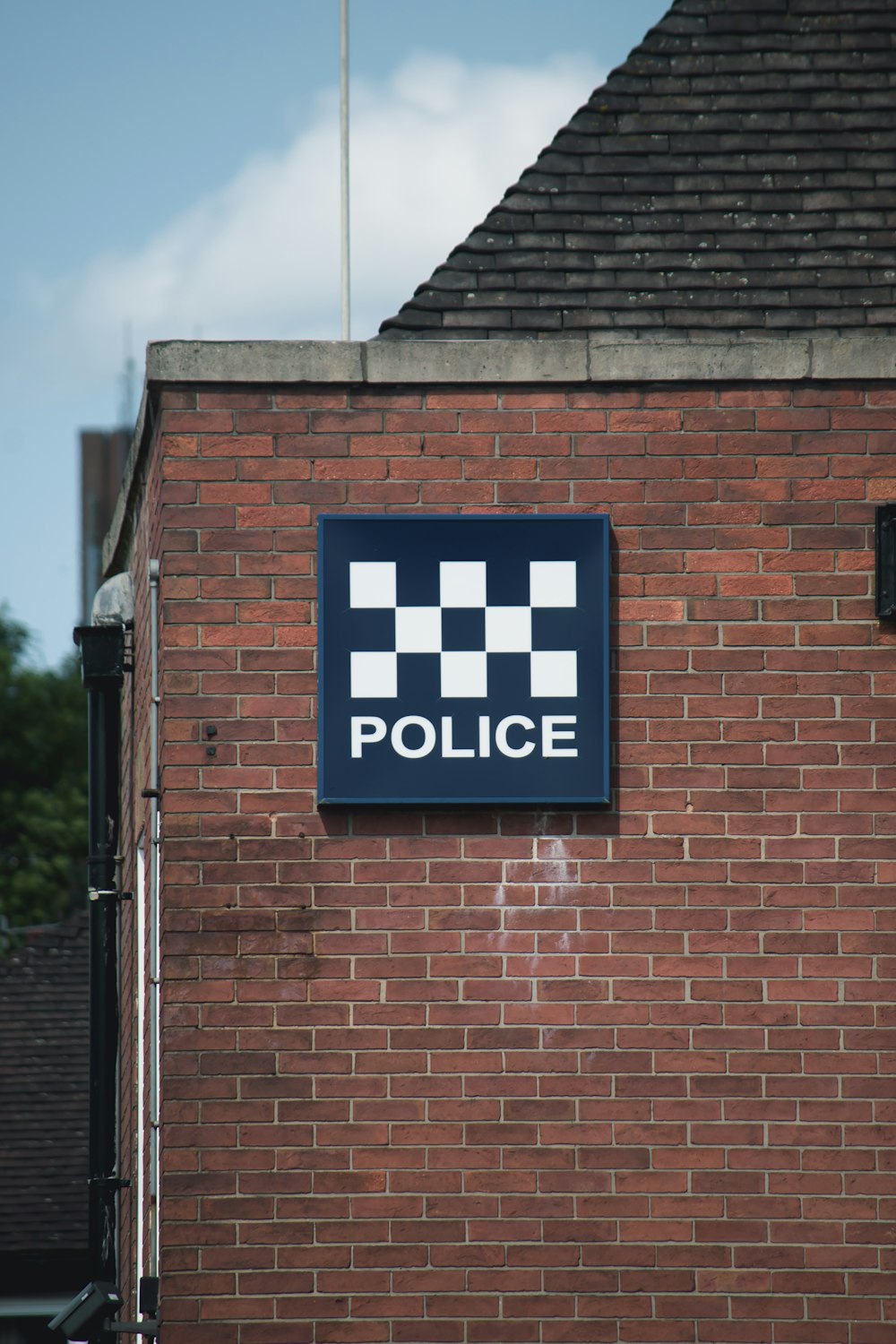 a police sign on the side of a brick building