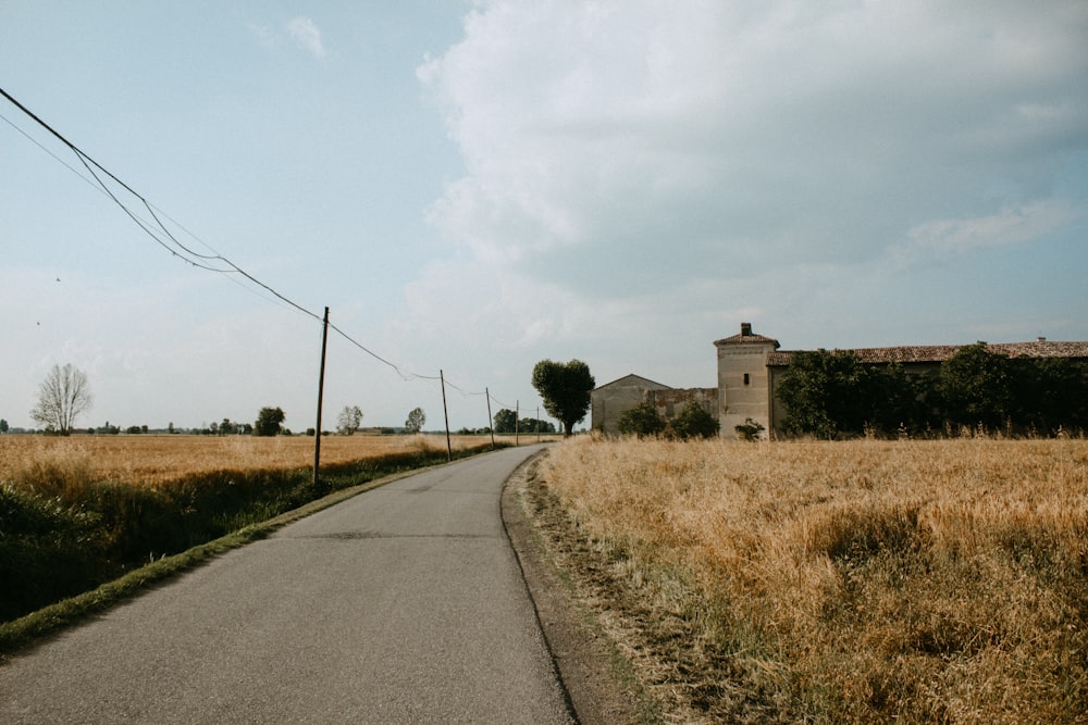 a rural road with a house in the distance