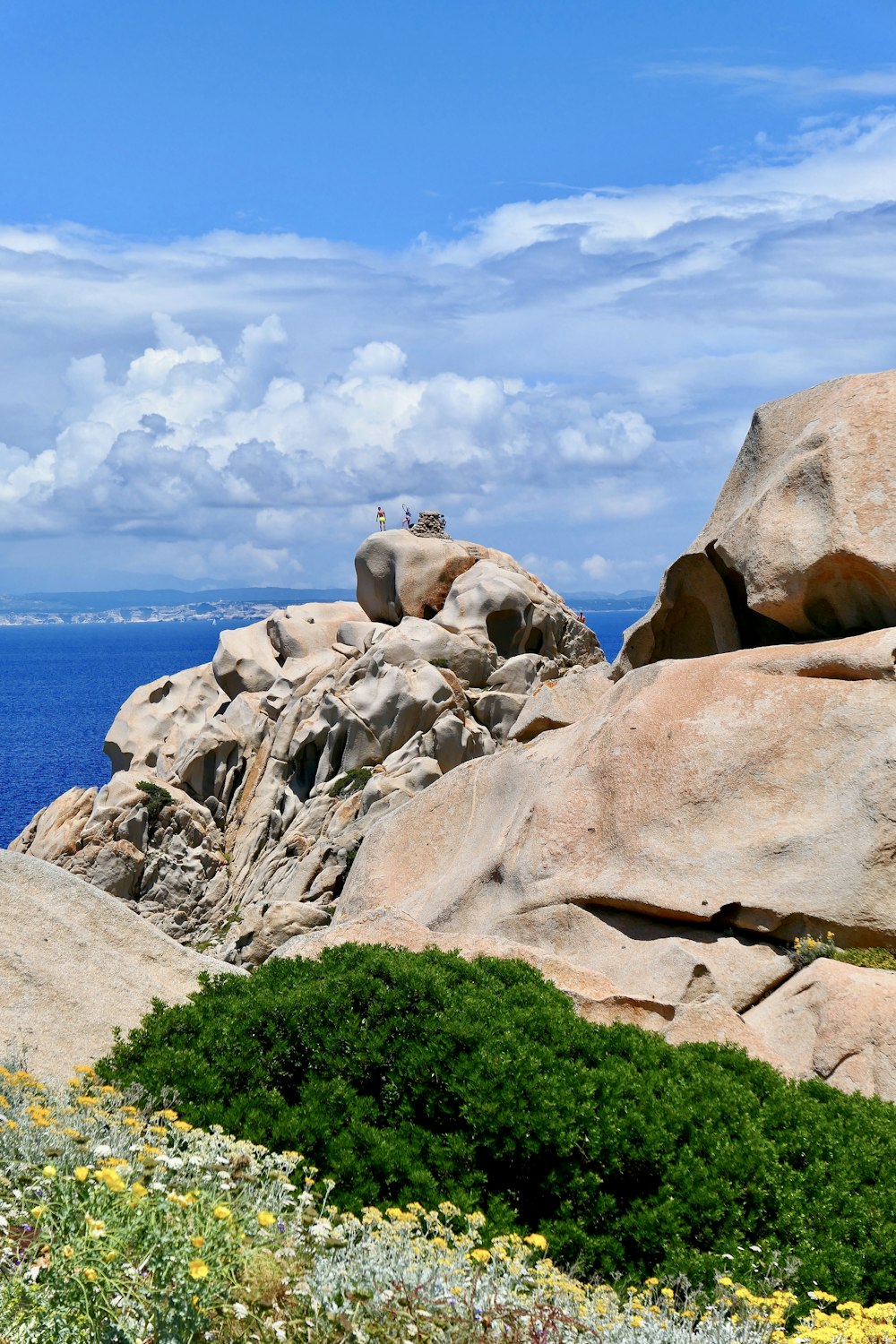 a rocky outcropping with a body of water in the background