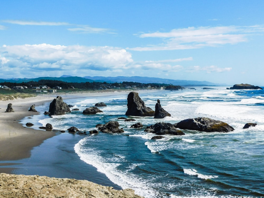 a view of a beach with rocks in the water