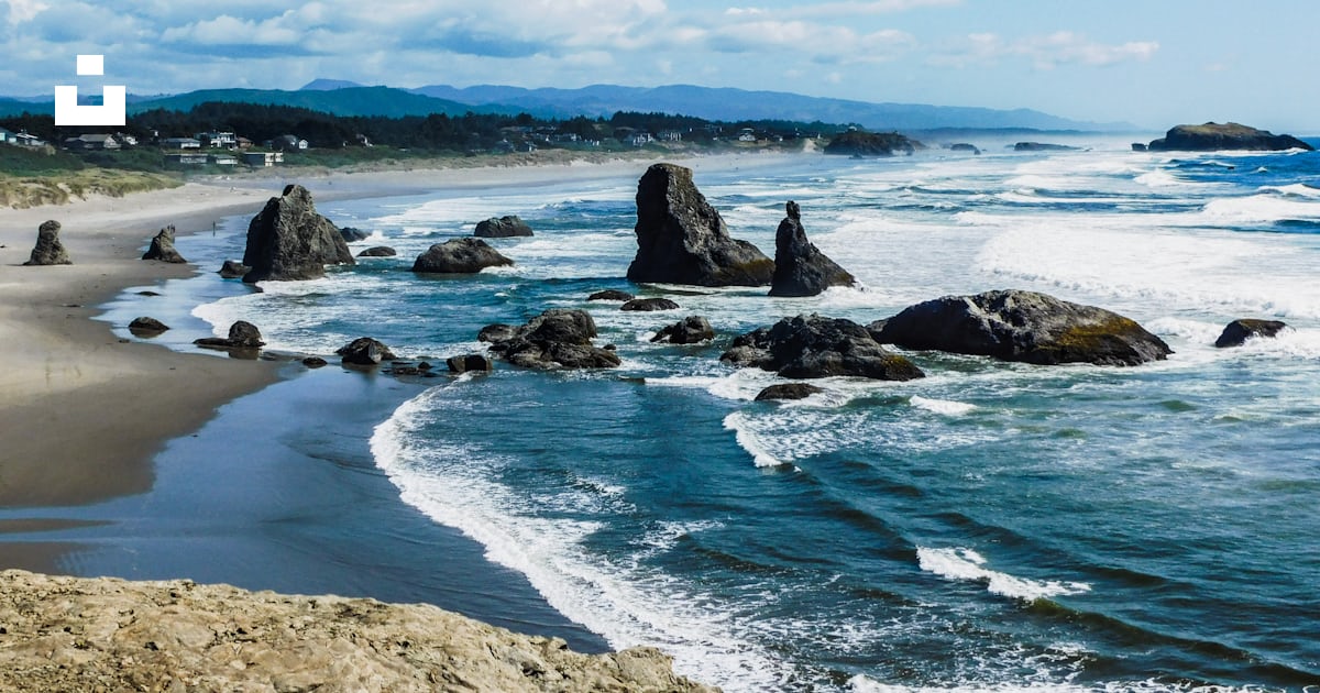 A view of a beach with rocks in the water photo โ Free Or Image on Unsplash