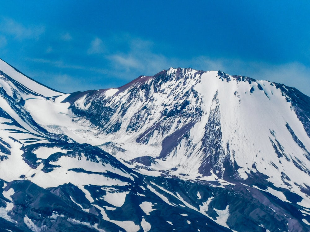 a mountain covered in snow under a blue sky