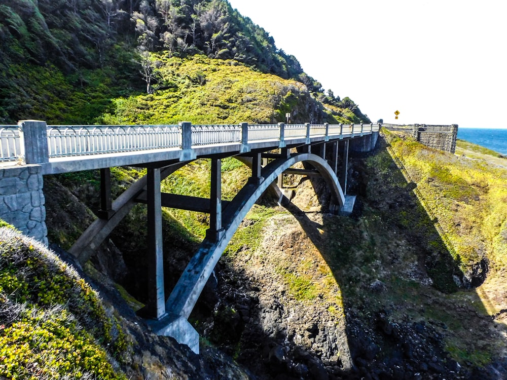 a bridge that is over a cliff by the ocean