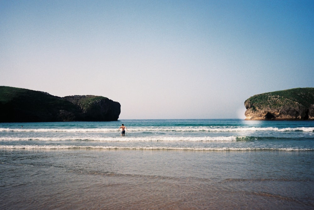 a person is standing in the water at the beach