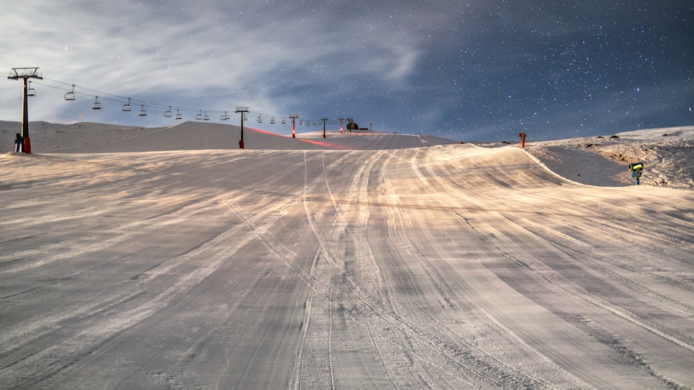 a person riding a snowboard down a snow covered slope