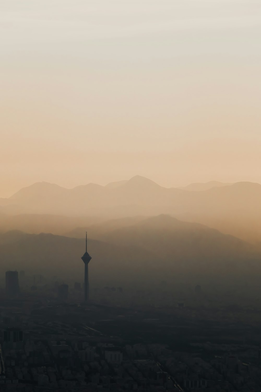 a hazy view of a city with mountains in the background