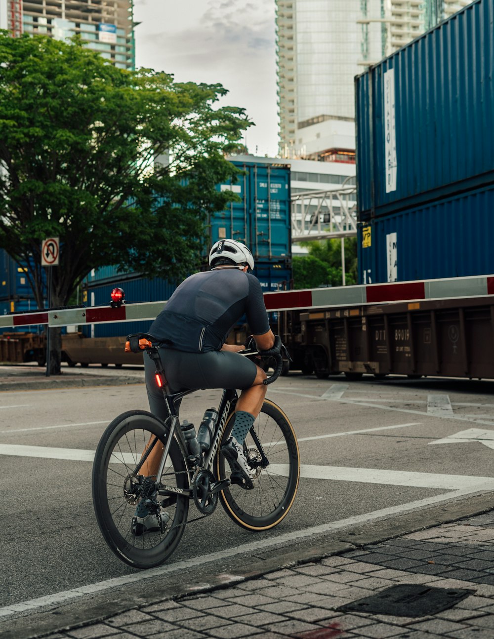 a man riding a bike down a street next to a train