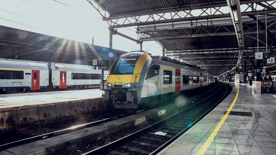 a yellow and white train pulling into a train station,