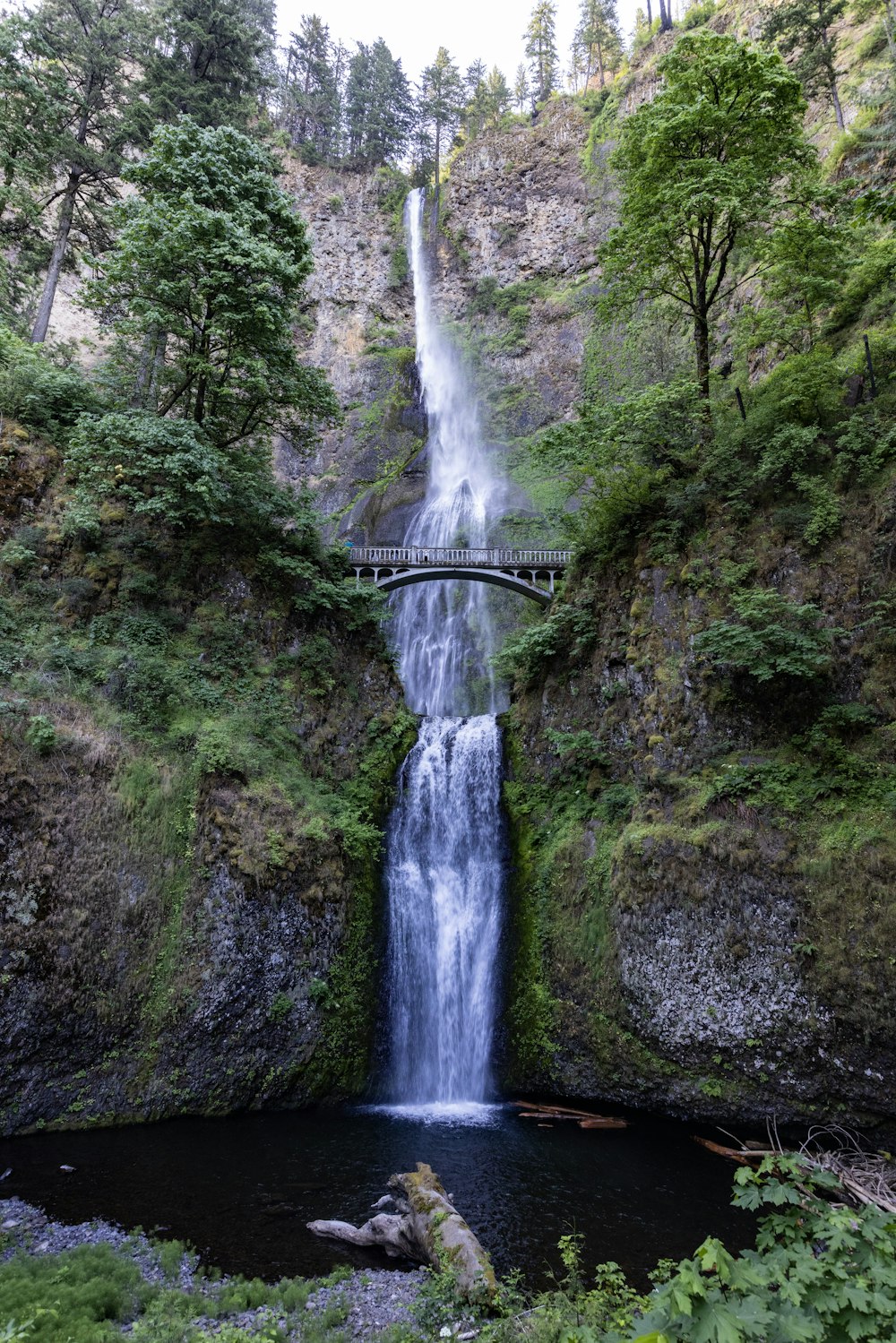 a large waterfall with a bridge over it