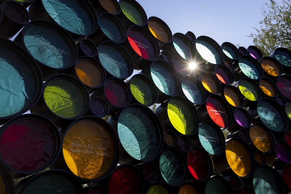 a large stack of multicolored traffic lights on a sunny day