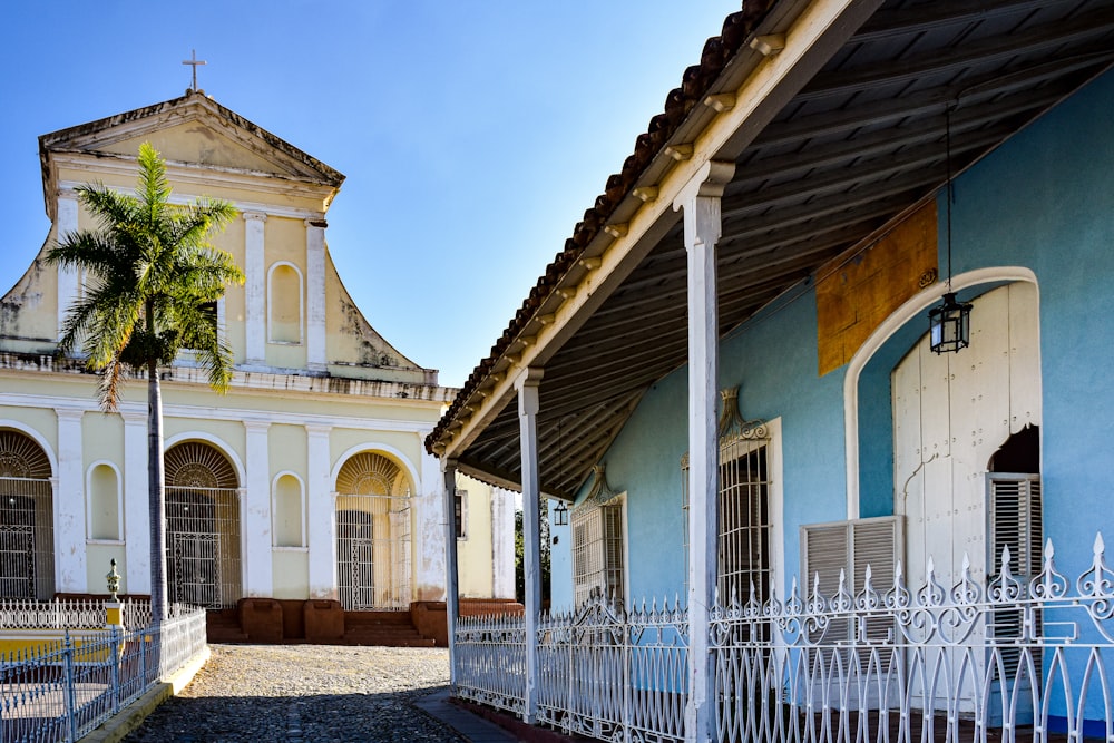 a blue and white building with a white fence