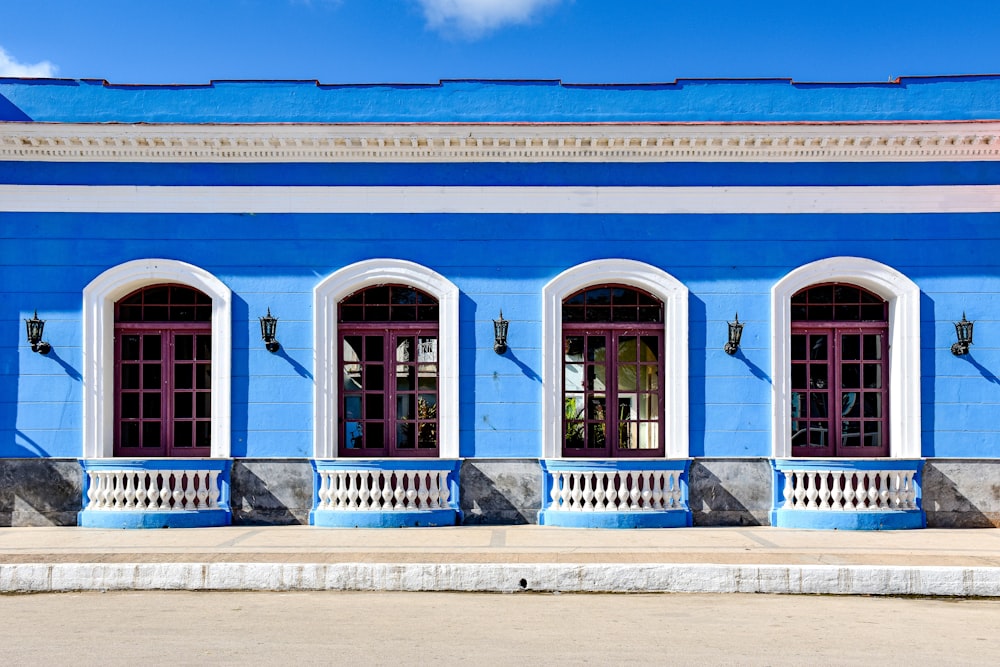 a blue and white building with three windows