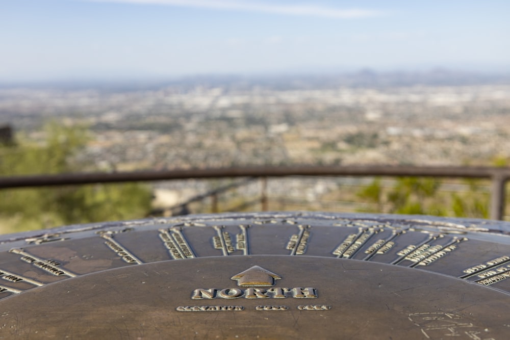 a close up of a metal object with a city in the background