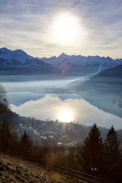 the sun is shining over the mountains and a lake