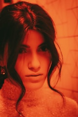 A warm ochre background portrait of a person with soft natural lighting.