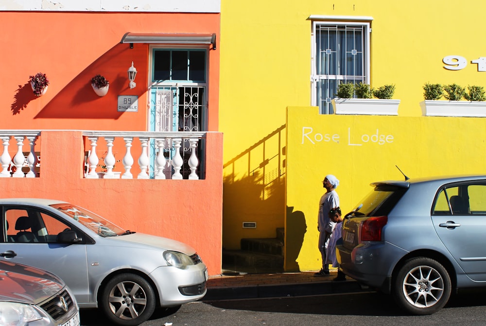 two cars parked next to each other in front of a building