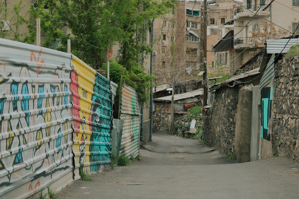 a narrow street with graffiti on the walls