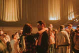 Guests laughing and dancing under soft amber lighting in the lounge area.