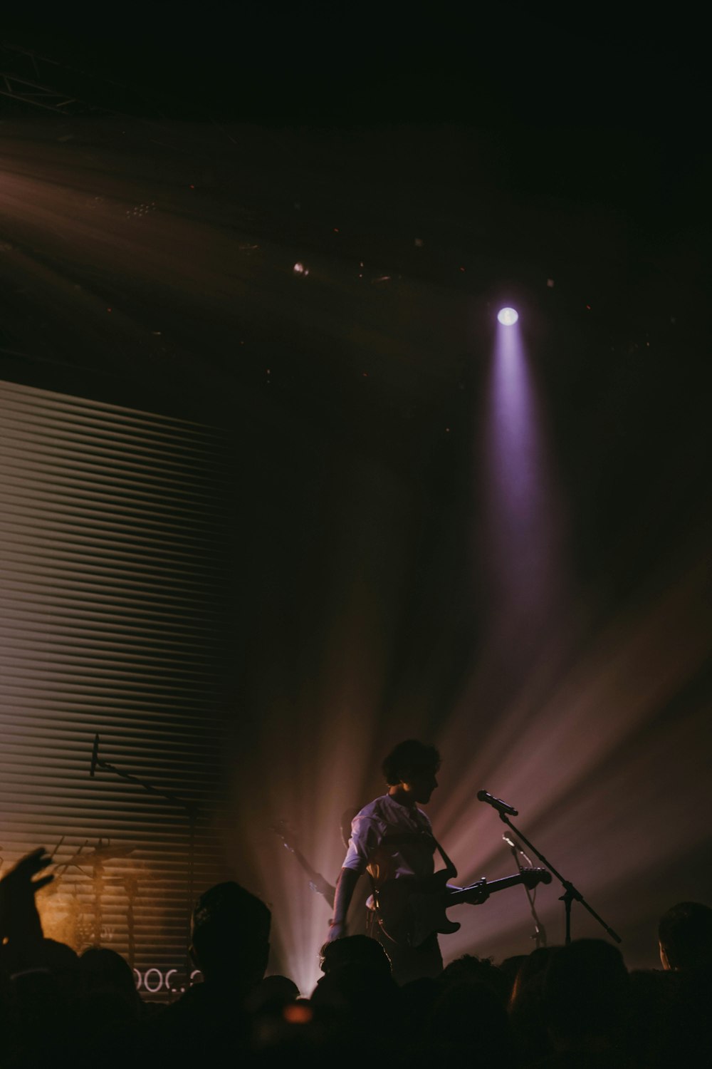 a man standing on top of a stage next to a microphone