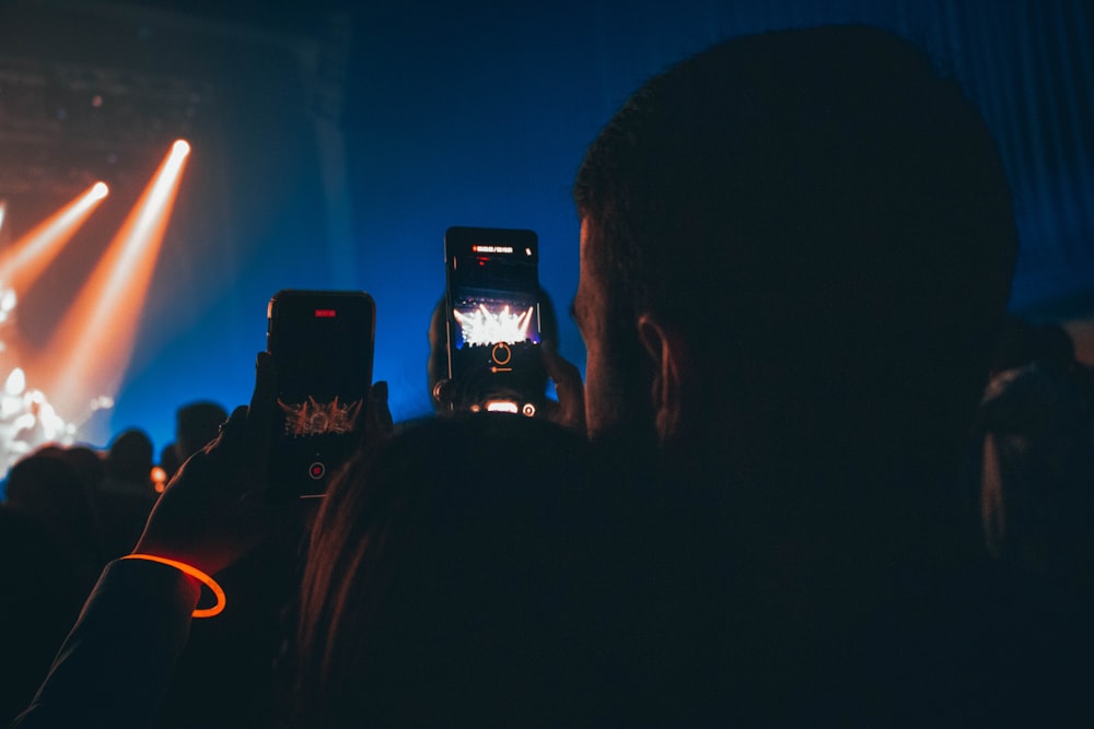 a person taking a picture of a concert with a cell phone