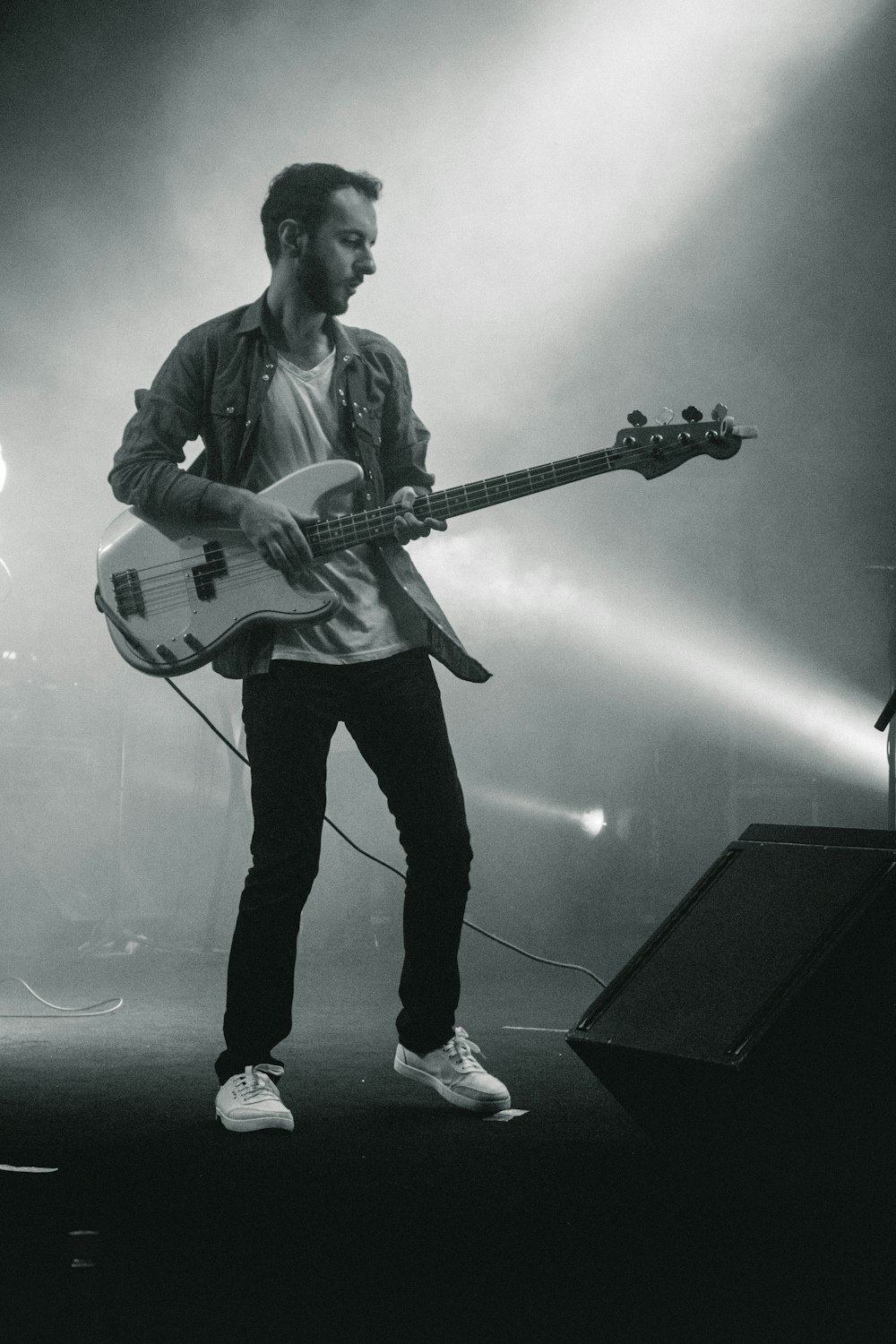 a man standing on a stage with a guitar